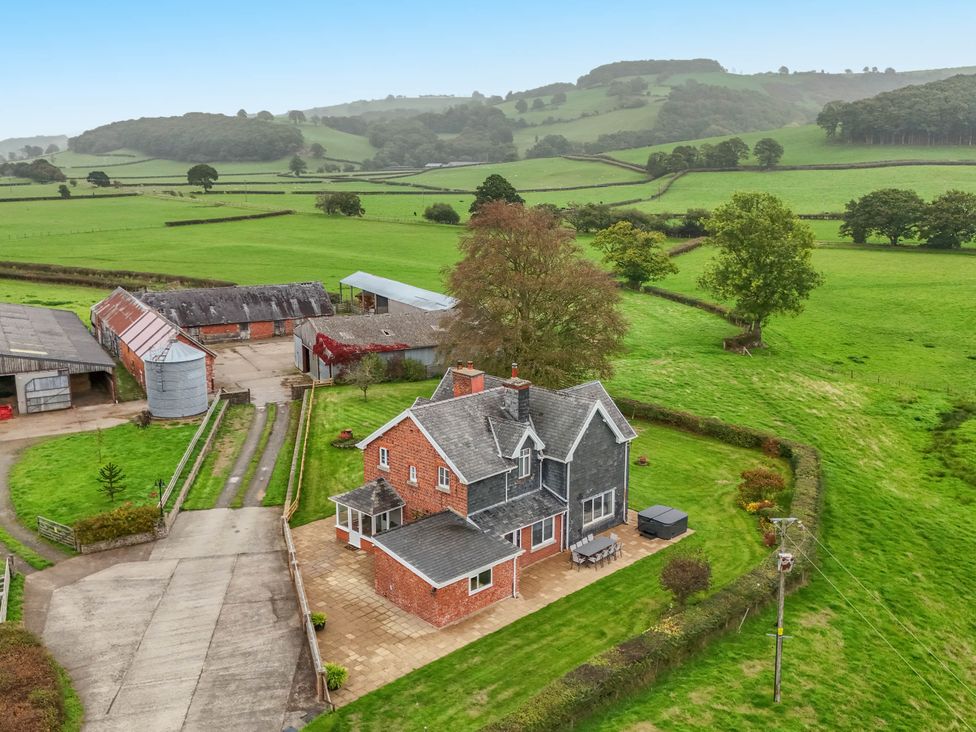 A house with farm buildings and fields at Pwll Glas in Trefeglwys