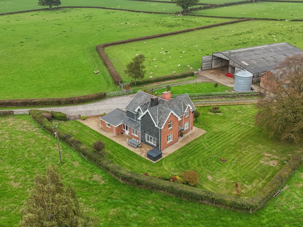 An aerial view of a house and barn with fields at Pwll Glas Trefeglwys