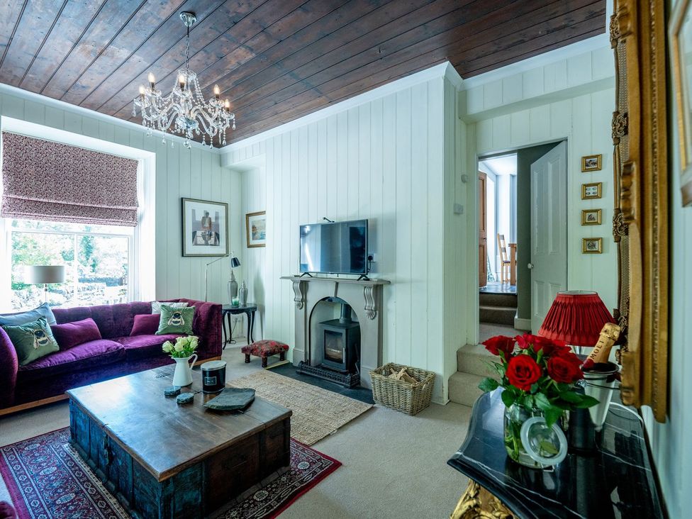 A living room with a television and sofa at Gwynfryn House in Llanbedr