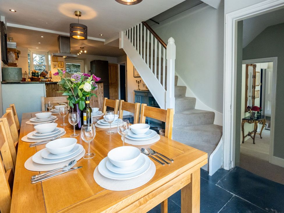 A dining room with a table set for a meal at Gwynfryn House in Llanbedr