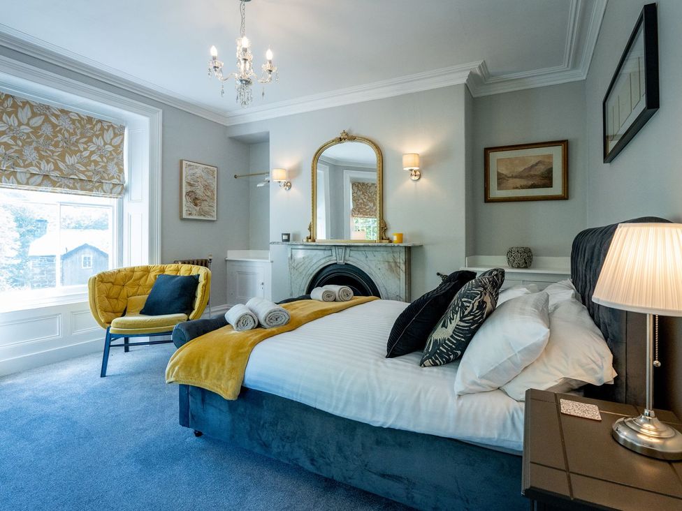 A bedroom with a bed and a sofa at Gwynfryn House in Llanbedr