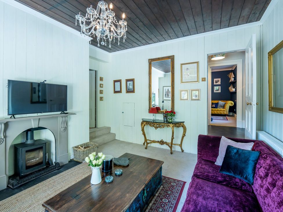 A living room with a television and fireplace at Gwynfryn House in Llanbedr