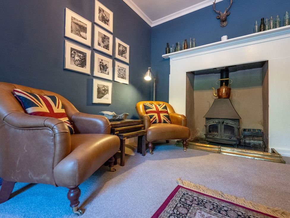 A living room with armchairs and a fireplace at Gwynfryn House in Llanbedr