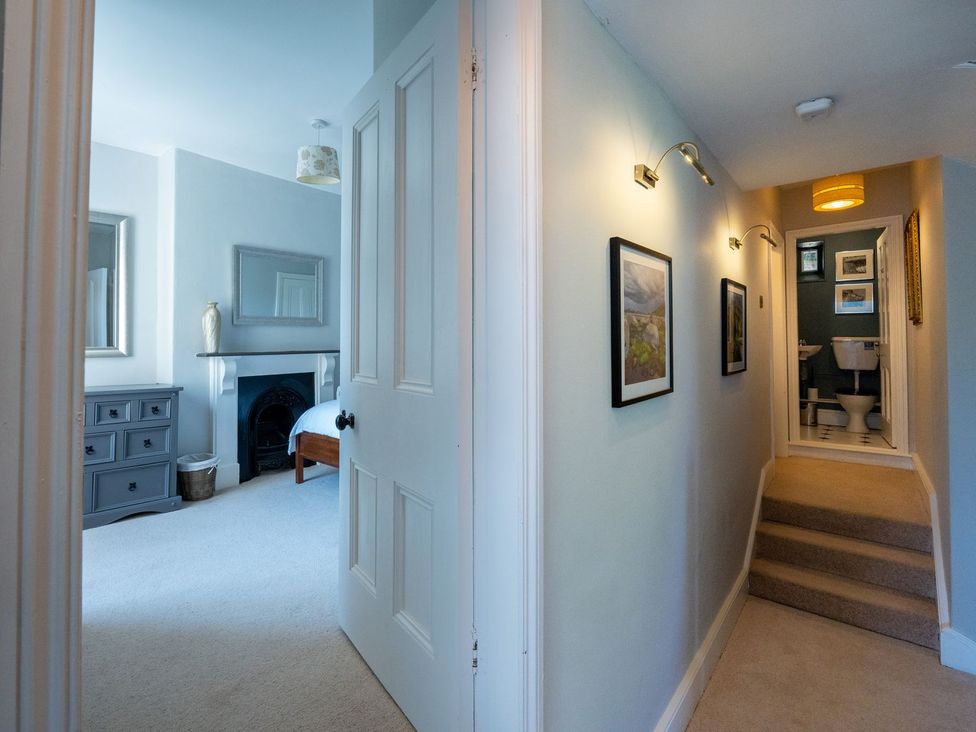 A hallway with a dresser and light fixtures at Gwynfryn House Llanbedr