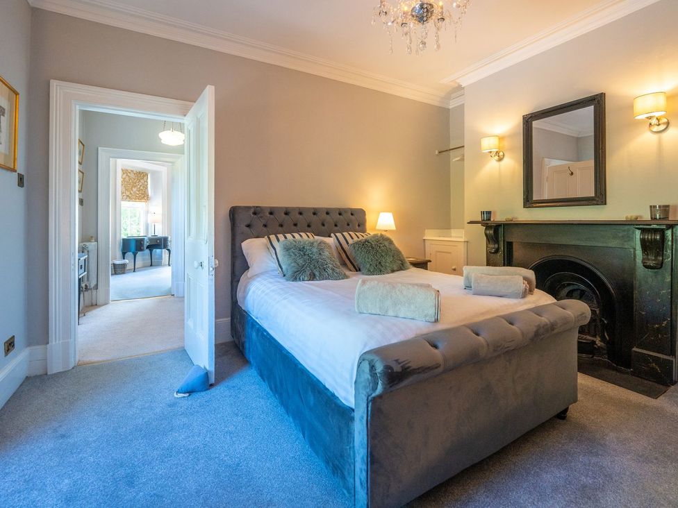 A bedroom with a bed and a fireplace at Gwynfryn House Llanbedr