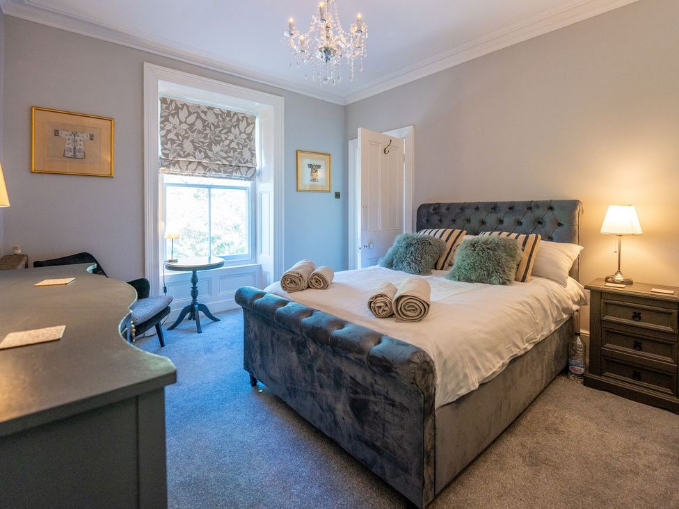 A bedroom with a bed and nightstand at Gwynfryn House in Llanbedr