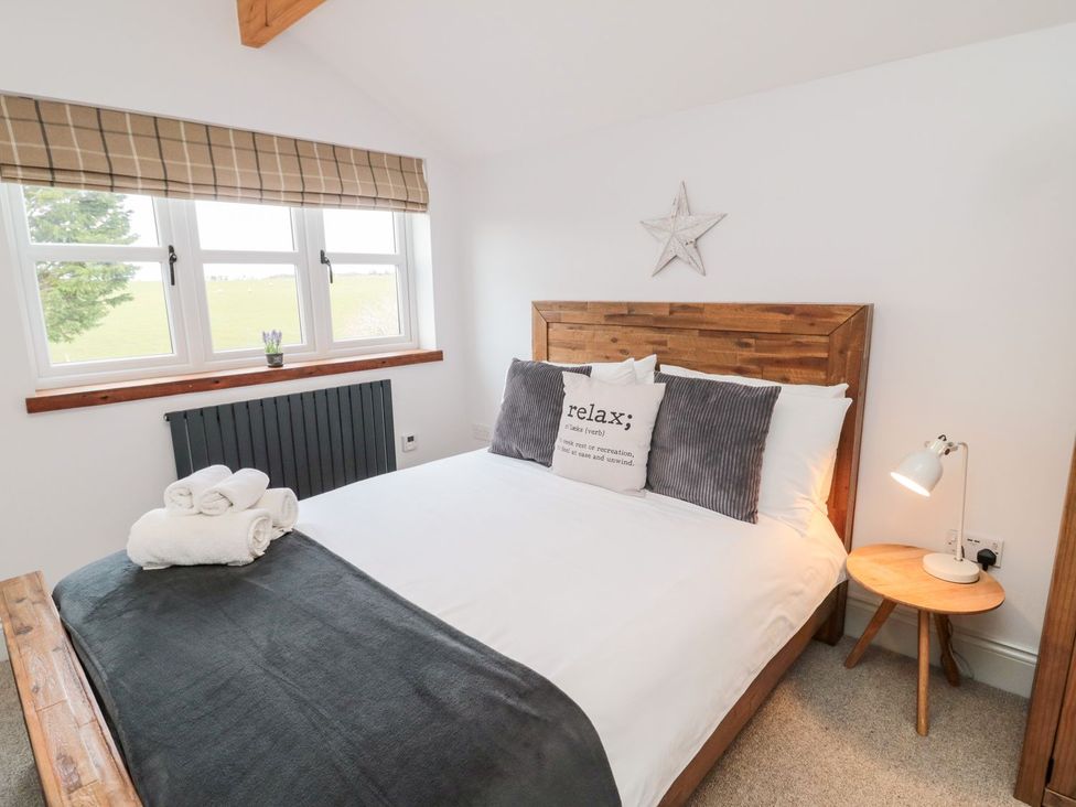 A bedroom with a bed and decorative items at Canny Cottage in Belford