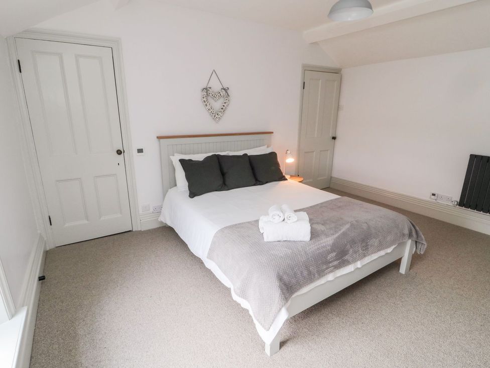 A bedroom with a bed and gray blanket at Canny Cottage in Belford