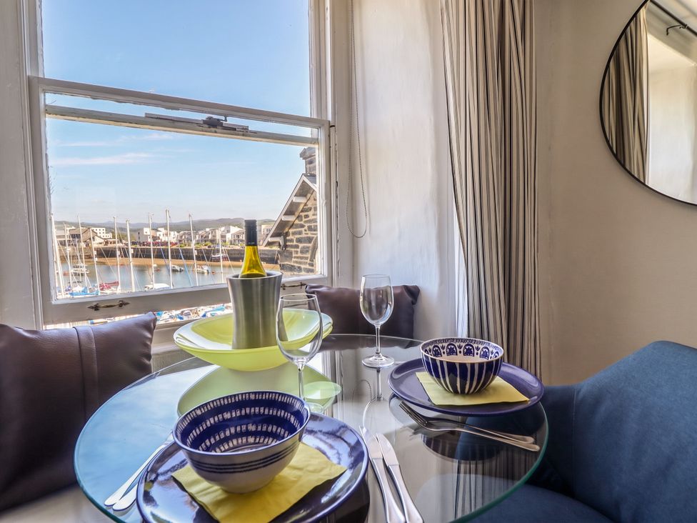 A dining table set with bowls and wine bottle at Cnicht View in Porthmadog