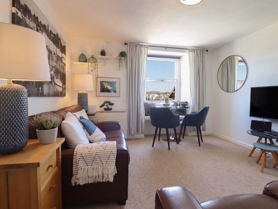 A living room with a sofa and dining area at Cnicht View in Porthmadog