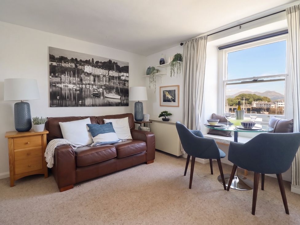 A living room with a sofa and dining table at Cnicht View in Porthmadog
