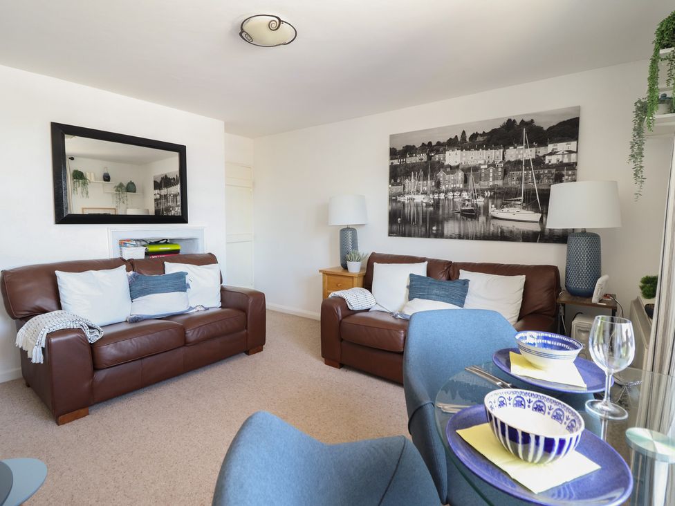 A living room with leather sofas and a mirror at Cnicht View in Porthmadog