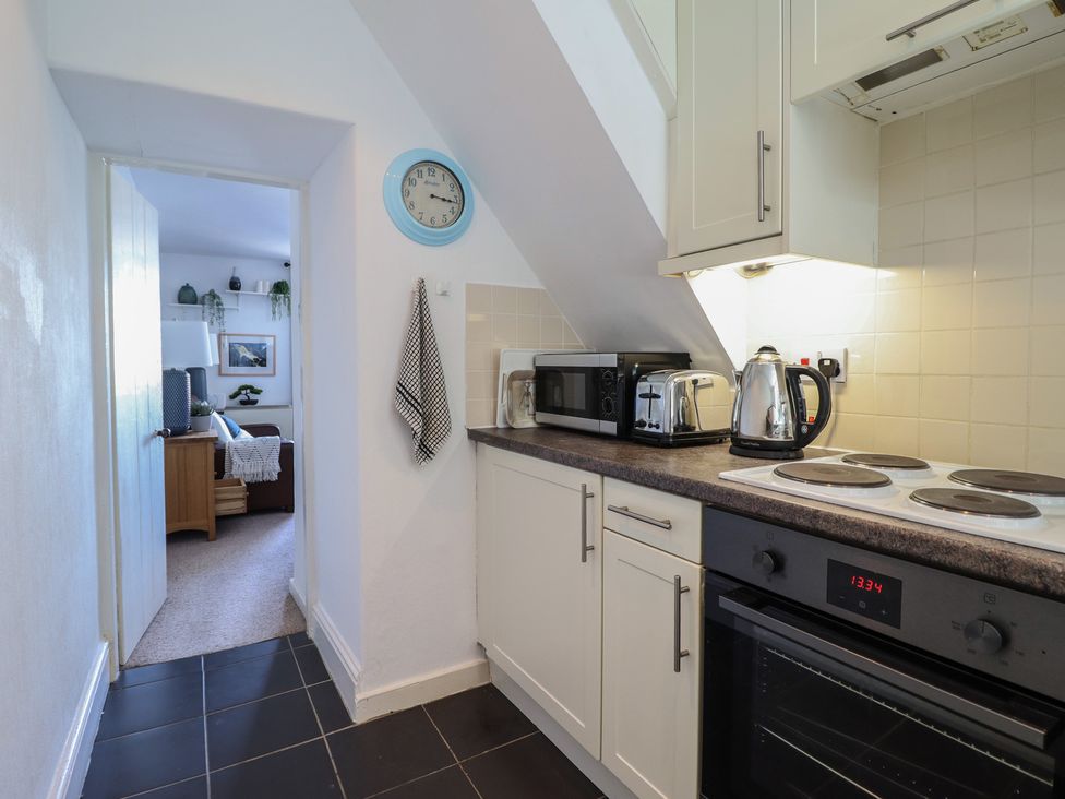 A kitchen with appliances and access to another room at Cnicht View in Porthmadog