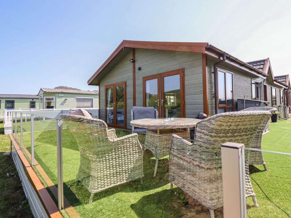 An outdoor seating area with a table and chairs at Excalabur 10 in Morfa Bychan