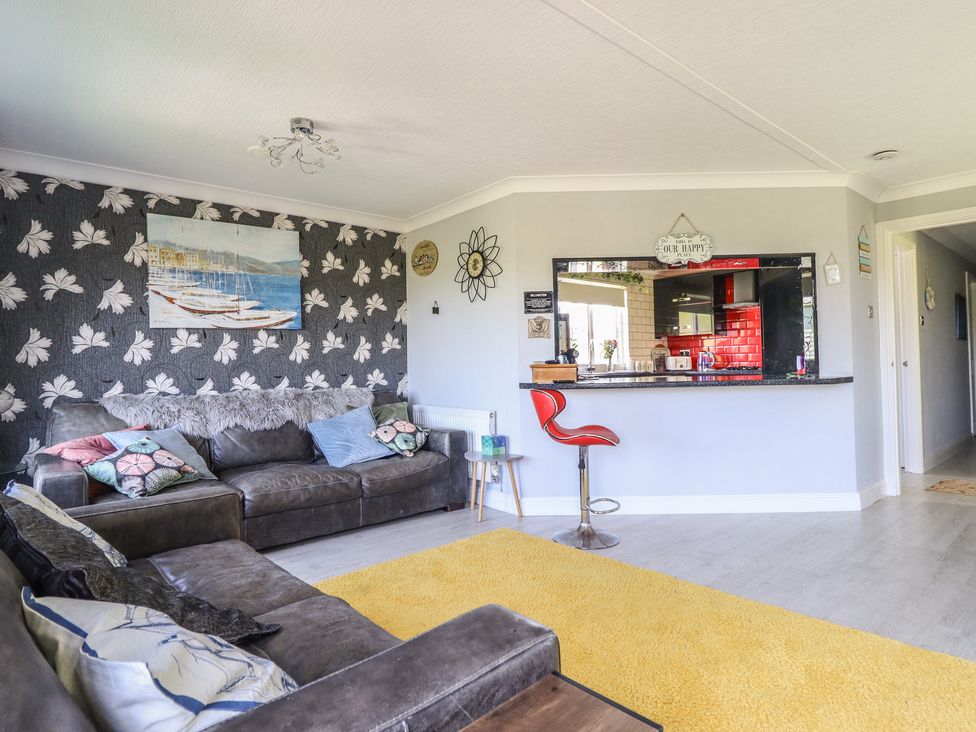 A living room with a sofa and bar counter at Excalabur 10 in Morfa Bychan
