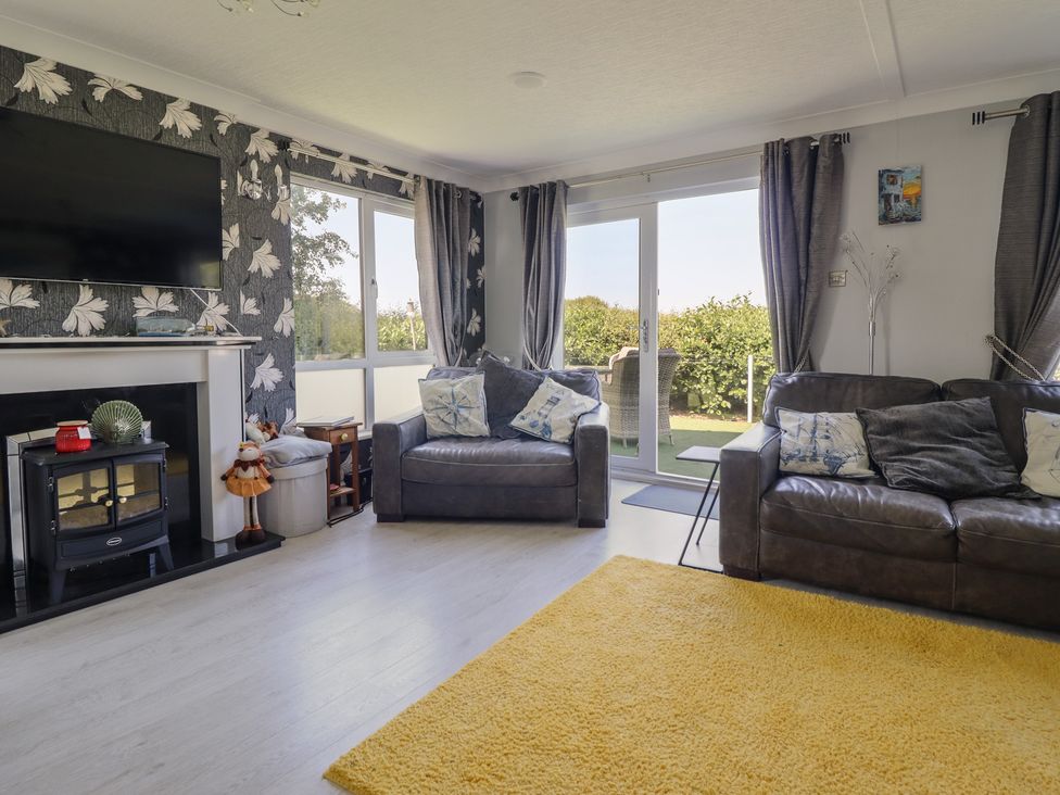 A living room with a television and sofa at Excalabur 10 Morfa Bychan