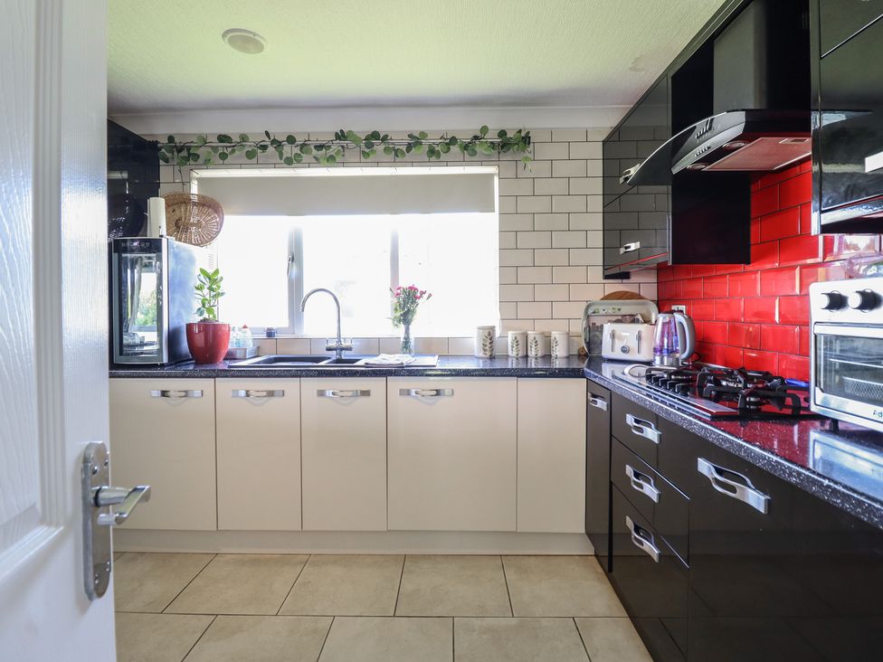 A kitchen with cabinets and appliances at Excalabur 10 in Morfa Bychan