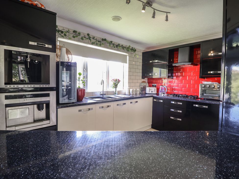 A kitchen with a sink and stove at Excalabur 10 in Morfa Bychan