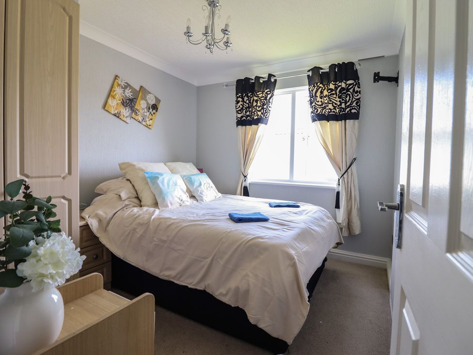 A bedroom with a bed and window at Excalabur 10 Morfa Bychan