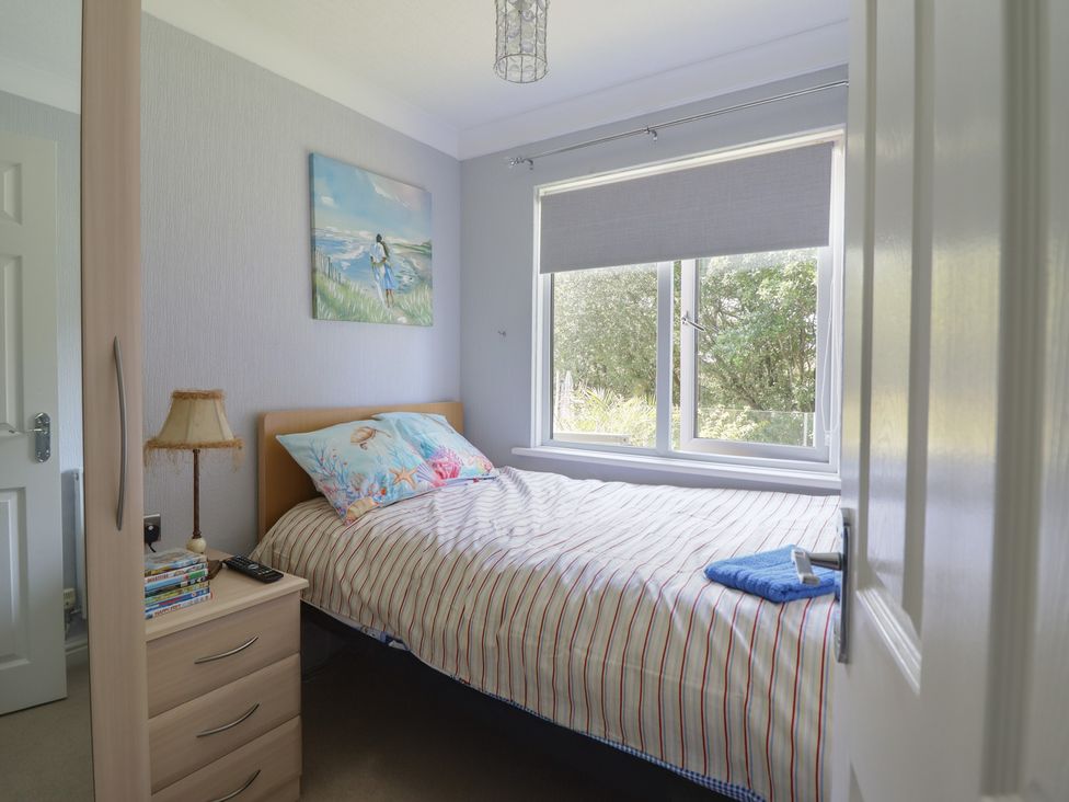 A bedroom with a bed and a lamp at Excalabur 10 in Morfa Bychan