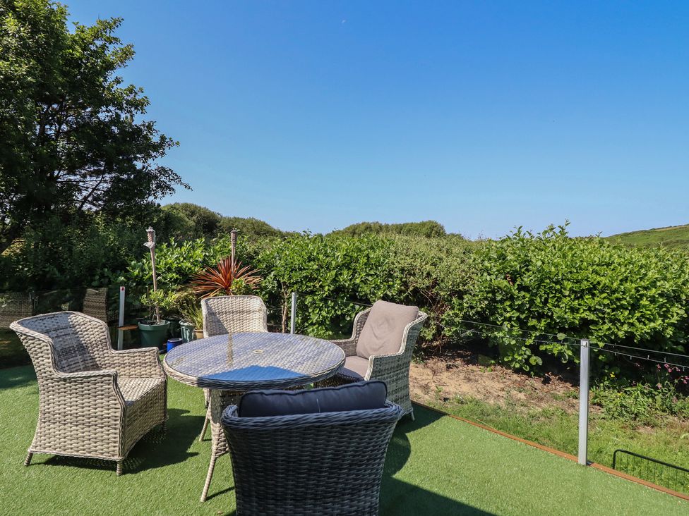 A garden with a table and chairs at Excalabur 10 Morfa Bychan