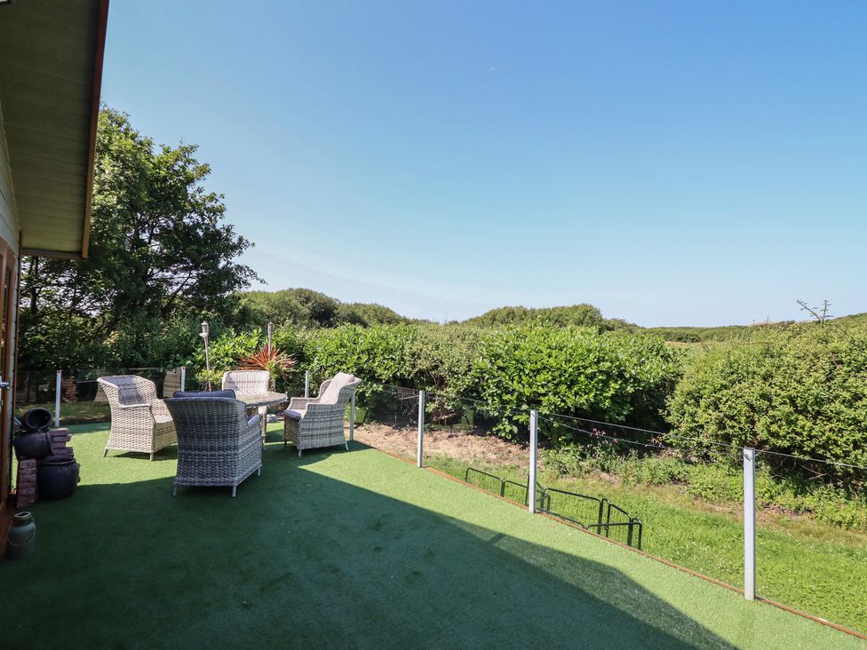 Outdoor area with chairs and table at Excalabur 10 in Morfa Bychan