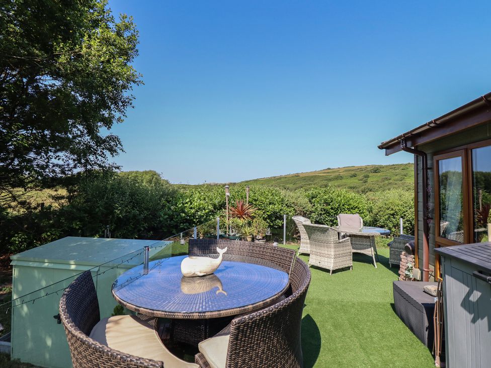 An outdoor seating area with a table and chairs at Excalabur 10 in Morfa Bychan