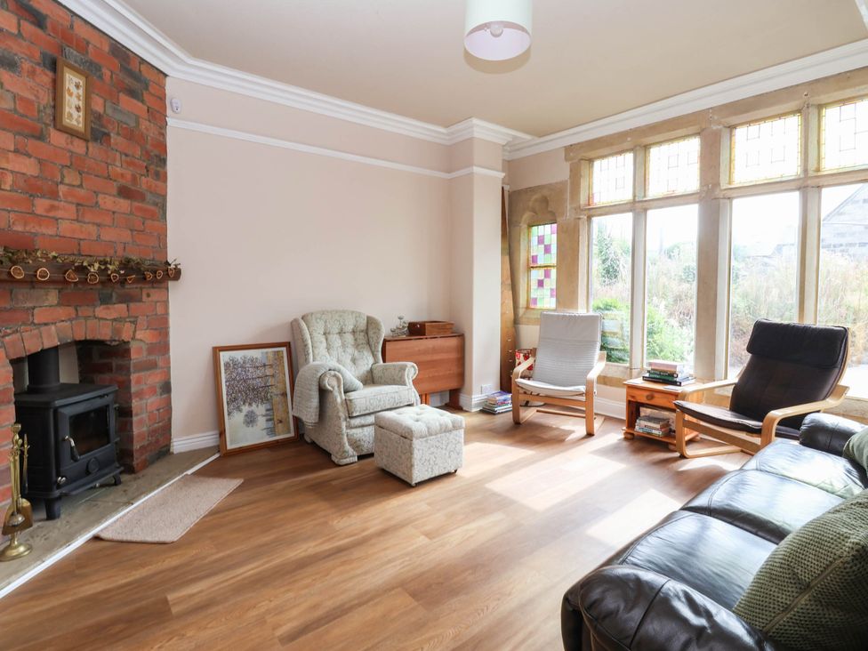 A living room with a brick fireplace and various seating at Burras Hill in Otley