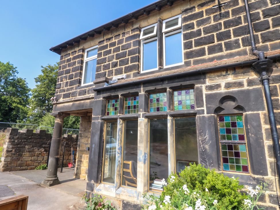 A building exterior with stained glass windows and plants at Burras Hill in Otley