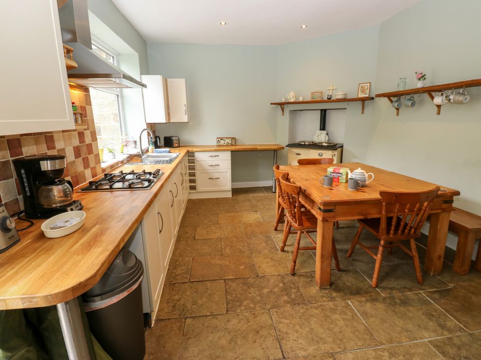 A kitchen with a stove, sink, and dining table at Burras Hill in Otley