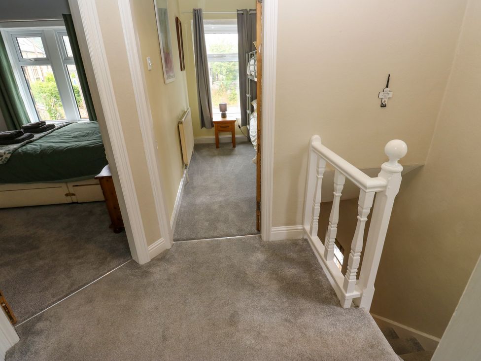 A hallway with a bed and chair at Burras Hill in Otley