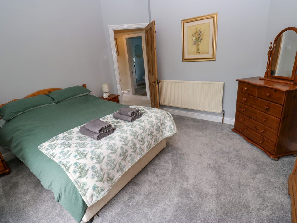 A bedroom with a bed, dresser, and towels at Burras Hill in Otley