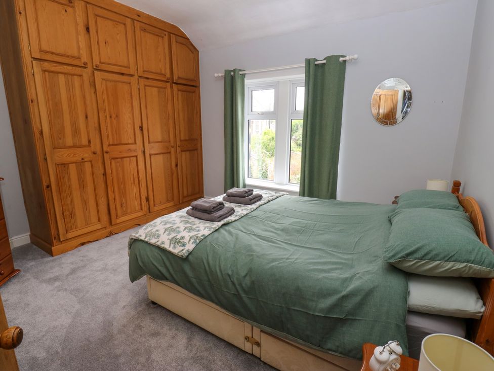 A bedroom with a bed and wardrobe at Burras Hill in Otley