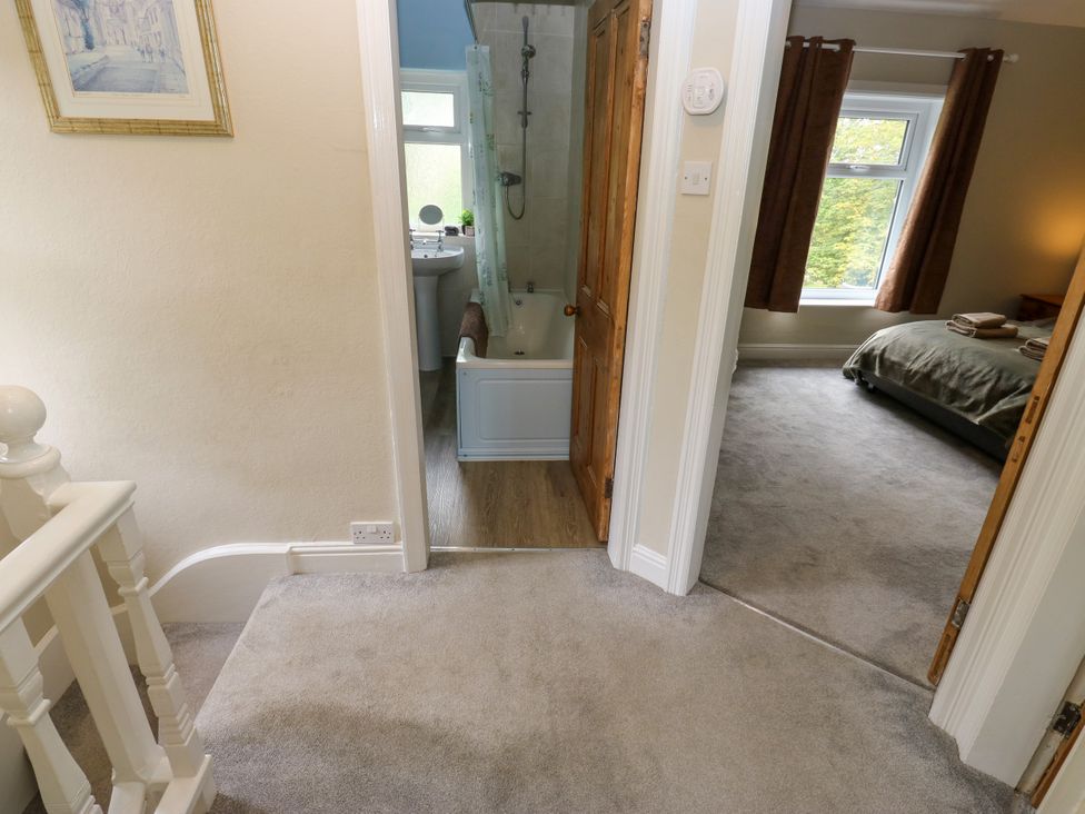 A bathroom with a bathtub and sink near a bedroom at Burras Hill in Otley