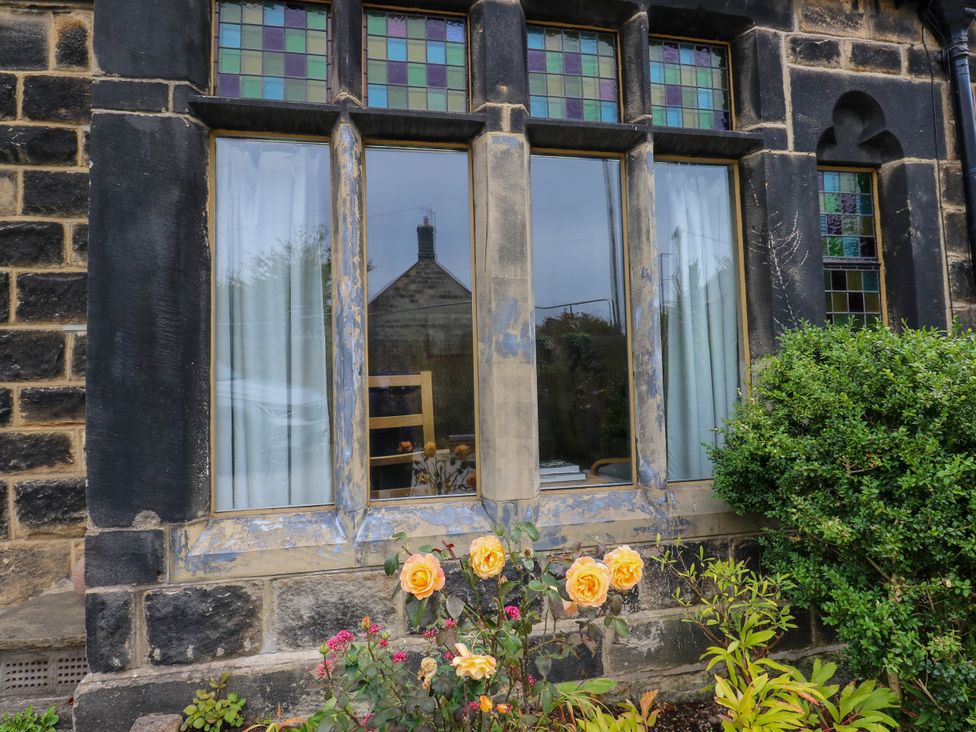 A window with stained glass and flowers at Burras Hill in Otley
