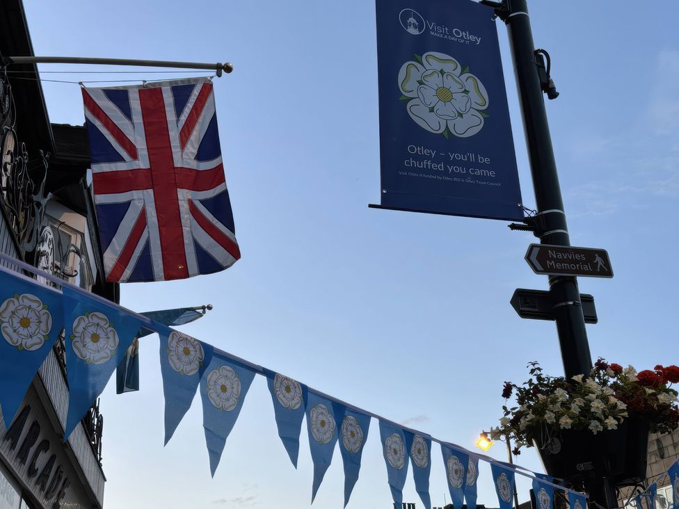 A street scene with a Union Jack flag and banners at Burras Hill in Otley
