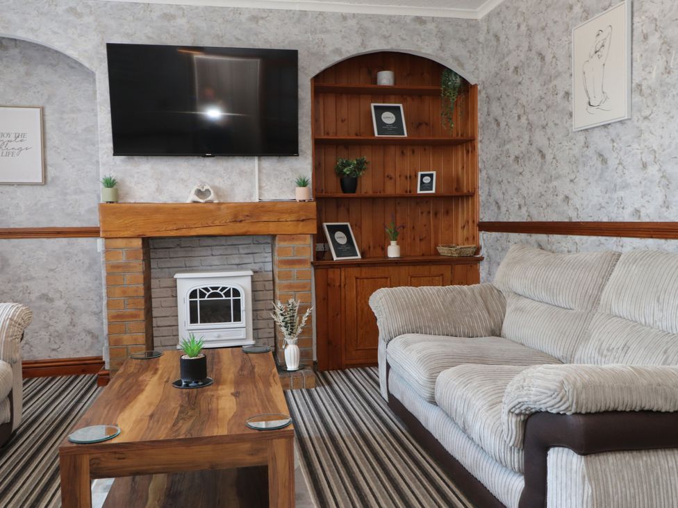A living room with a television and a coffee table at 31 Ffordd Y Maer in Pwllheli