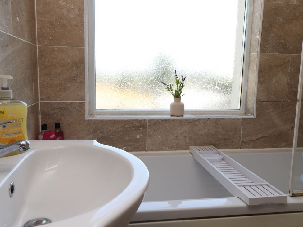 A sink and bathtub in a bathroom at 31 Ffordd Y Maer Pwllheli