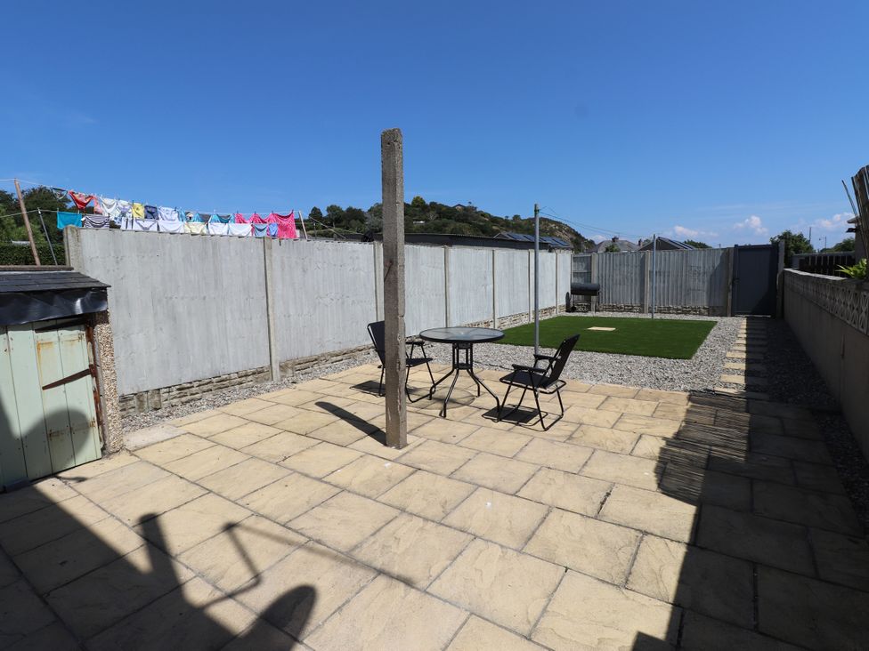 A garden with a table and chairs at 31 Ffordd Y Maer in Pwllheli