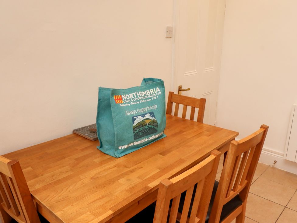 A dining room with a wooden table and chairs at 19 Dunstan View Seahouses