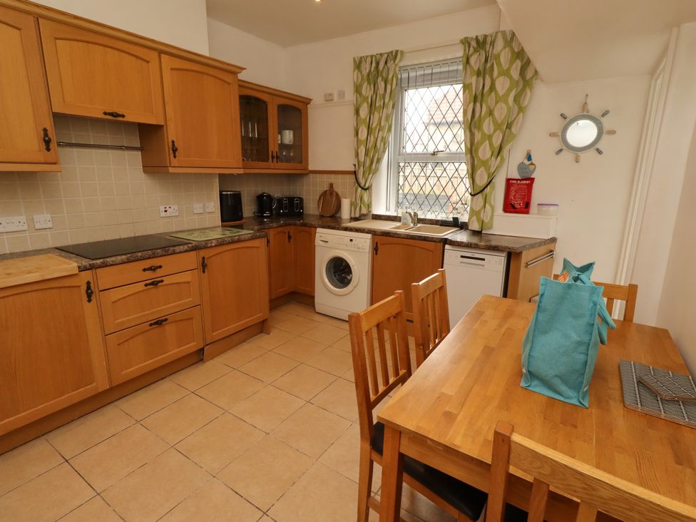 A kitchen with cabinets and appliances at 19 Dunstan View Seahouses