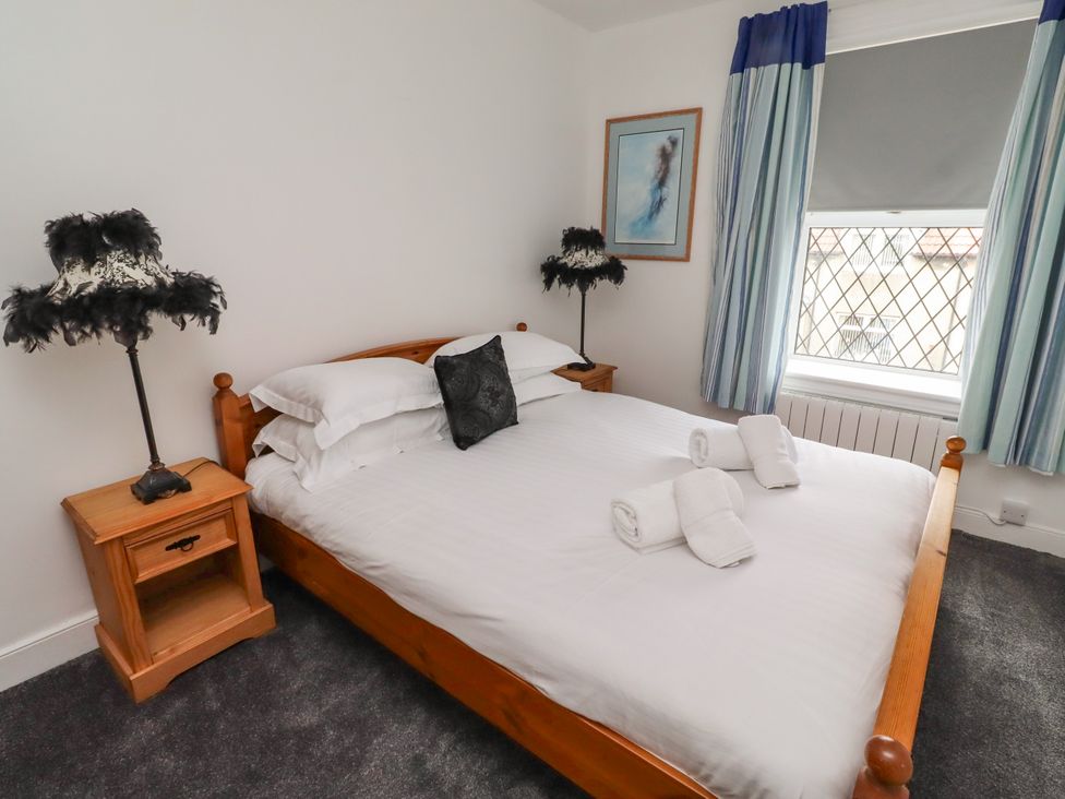 A bedroom with a double bed and nightstand at 19 Dunstan View Seahouses