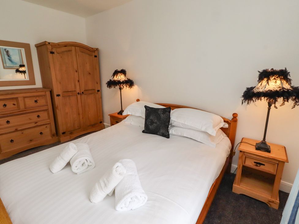 A bedroom with a bed and wardrobe at 19 Dunstan View in Seahouses