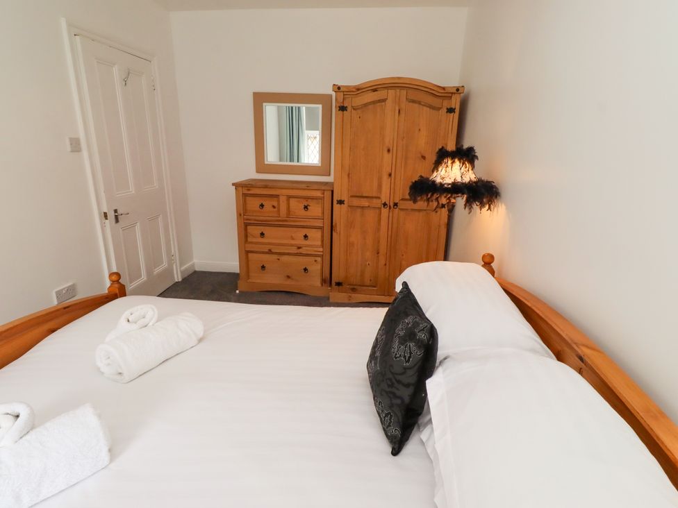A bedroom with a bed and dresser at 19 Dunstan View in Seahouses