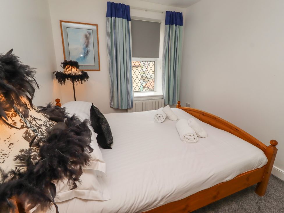 A bedroom with a bed and towels in the room at 19 Dunstan View Seahouses