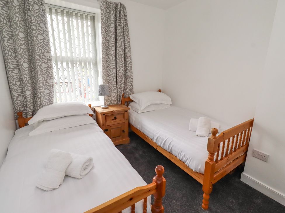 A bedroom with two single beds and a nightstand at 19 Dunstan View Seahouses