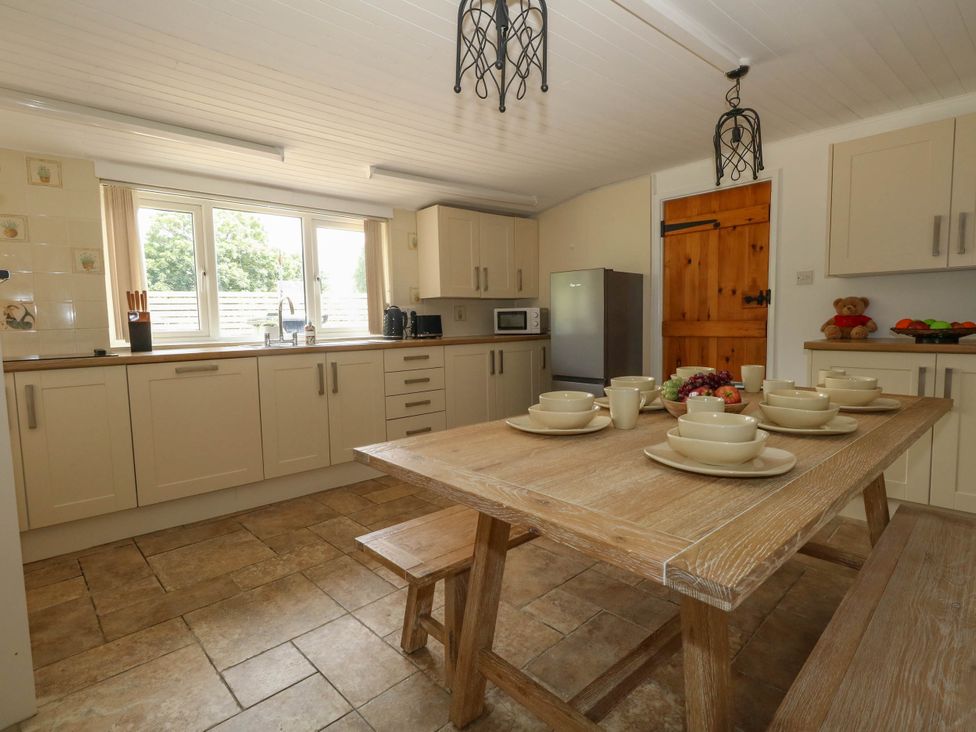 A kitchen with a table set for dining at Greenwich Cottage in Burton Bradstock