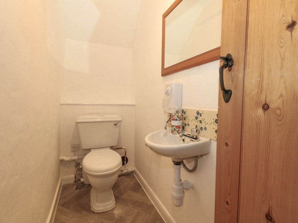 A bathroom with a toilet and sink at Greenwich Cottage in Burton Bradstock