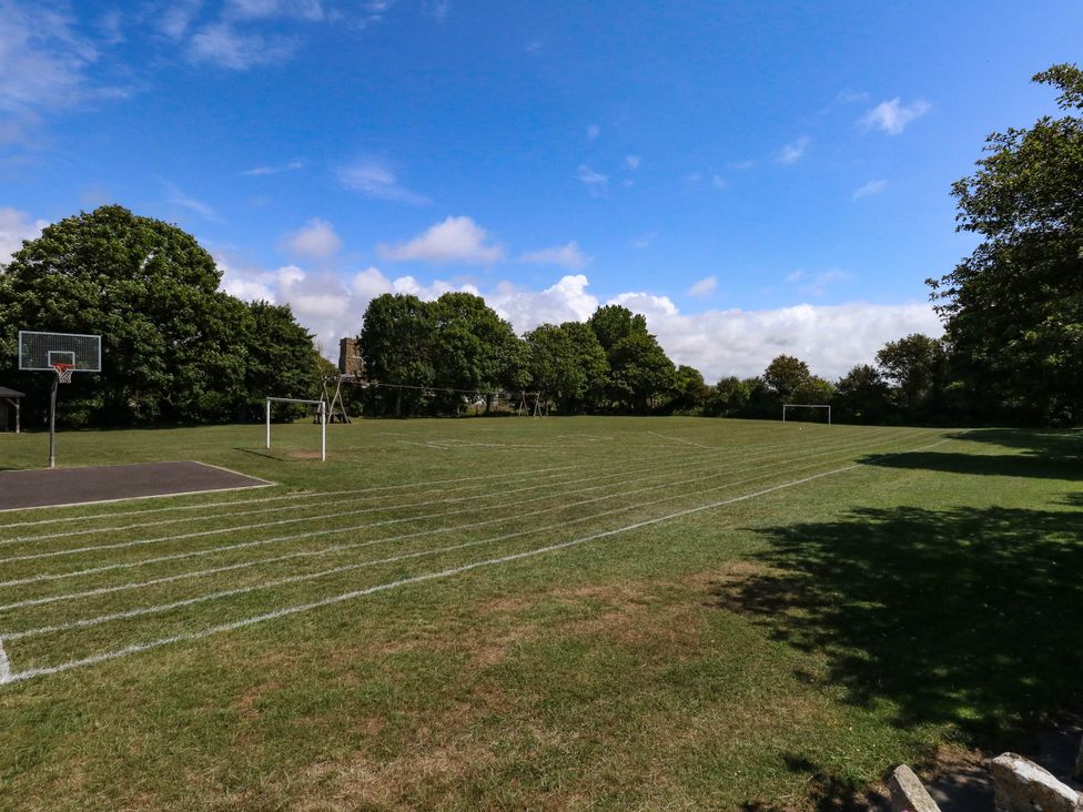 An outdoor area with a basketball hoop and soccer goals at Greenwich Cottage in Burton Bradstock