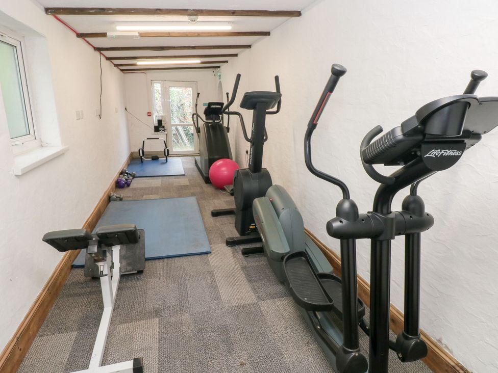 A gym with exercise equipment and mats at Number 19 Ferryside